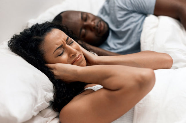 woman can't sleep because of snoring man